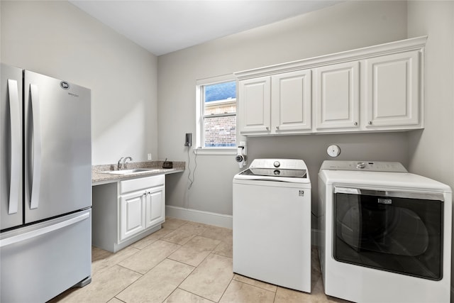 clothes washing area featuring sink, light tile patterned flooring, and washer and clothes dryer