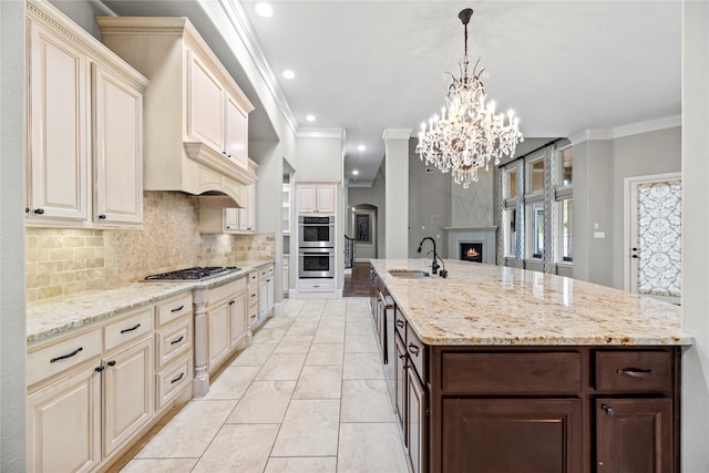 kitchen featuring dark brown cabinets, stainless steel appliances, ornamental molding, sink, and light stone counters