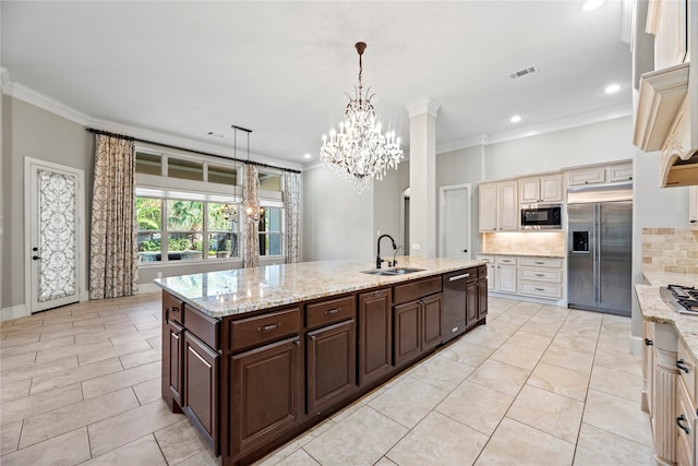 kitchen with decorative backsplash, built in appliances, pendant lighting, dark brown cabinetry, and sink