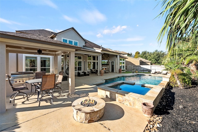 view of pool featuring an in ground hot tub, ceiling fan, a patio area, and a fire pit