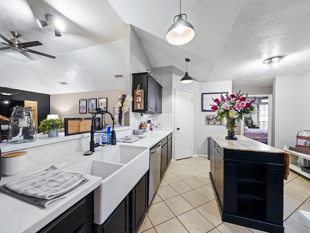 kitchen featuring light tile patterned flooring, a kitchen island, a textured ceiling, lofted ceiling, and decorative light fixtures