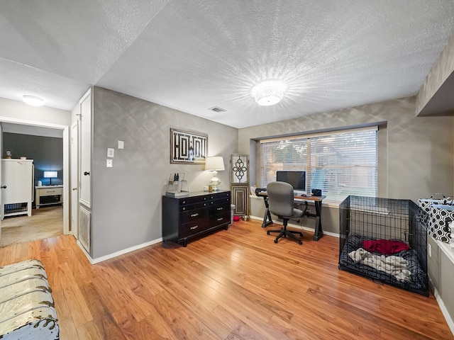 office area featuring a textured ceiling and light hardwood / wood-style floors