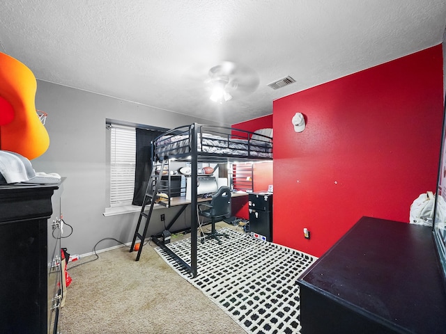 bedroom with a textured ceiling, carpet flooring, and ceiling fan