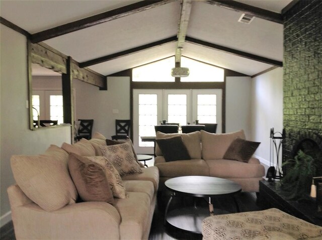 living room with vaulted ceiling with beams, hardwood / wood-style floors, and a fireplace