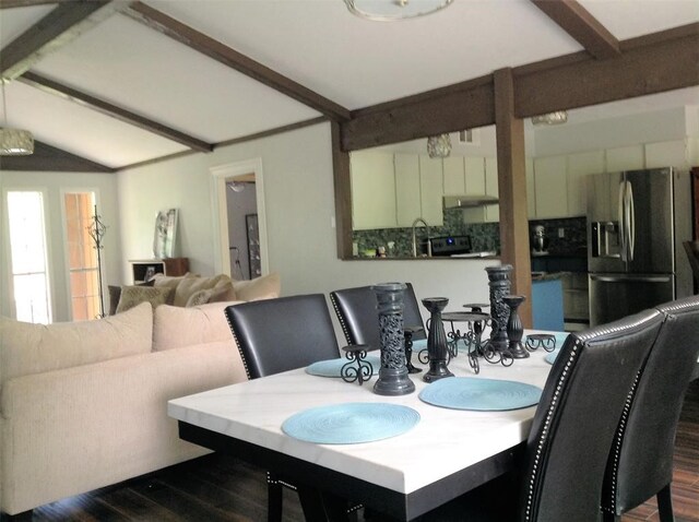 dining area with dark wood-type flooring, beamed ceiling, and sink