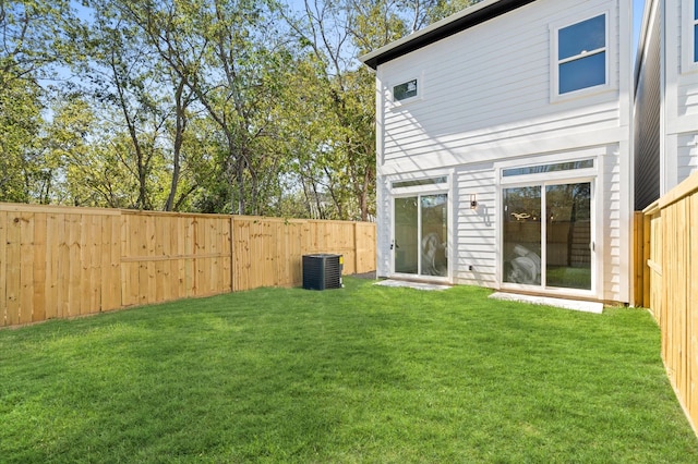 back of house with a yard and central AC unit