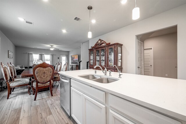 kitchen featuring white cabinetry, light hardwood / wood-style flooring, decorative light fixtures, and sink