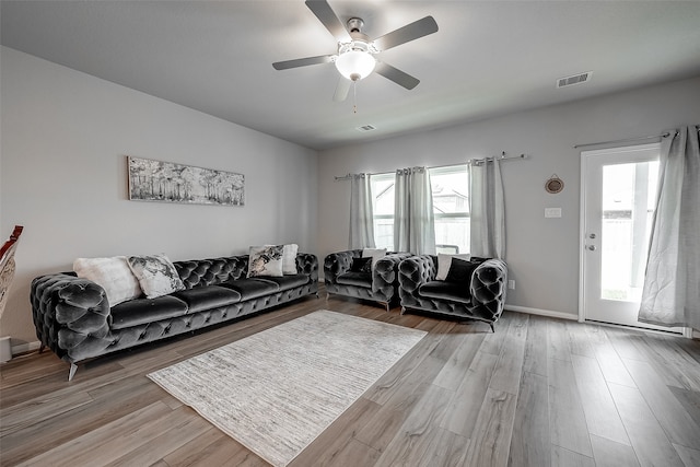 living room featuring ceiling fan and light hardwood / wood-style flooring