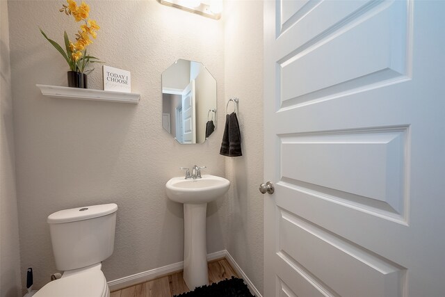 bathroom featuring sink, wood-type flooring, and toilet