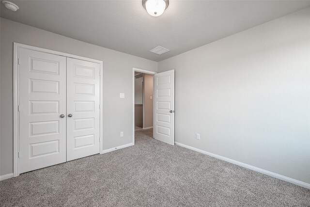 unfurnished bedroom with carpet floors and a closet