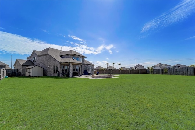 back of house featuring a patio, a storage shed, and a lawn