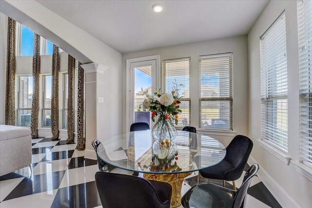 dining room featuring decorative columns and tile patterned floors