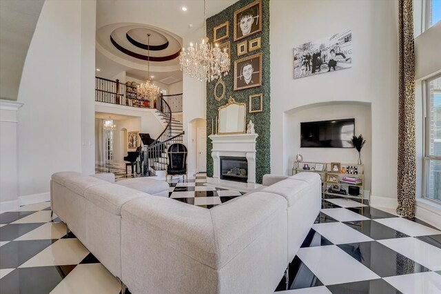 living room with a notable chandelier, a towering ceiling, and a wealth of natural light