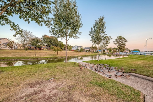 surrounding community with a lawn and a water view