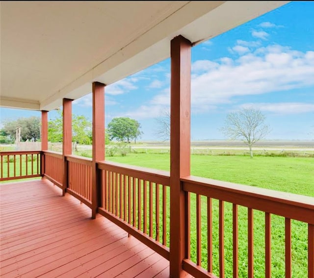 wooden terrace with a rural view and a yard