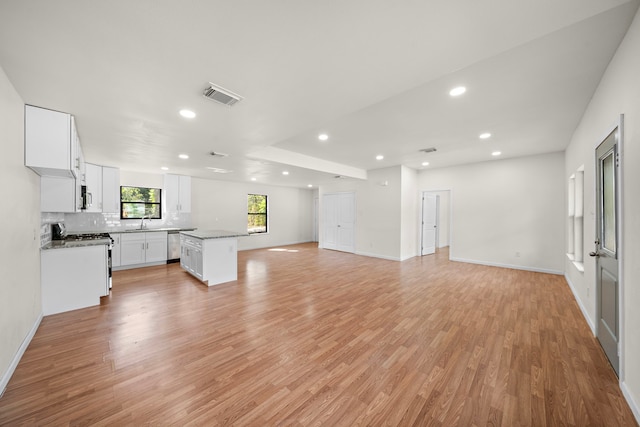 unfurnished living room with sink and light wood-type flooring