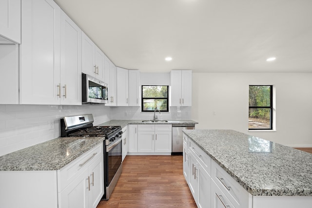 kitchen featuring white cabinetry, stainless steel appliances, plenty of natural light, and hardwood / wood-style floors