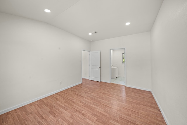 unfurnished room with vaulted ceiling and light hardwood / wood-style floors