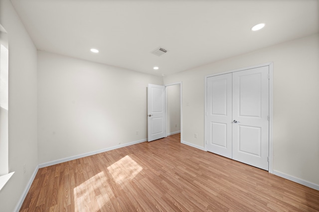 unfurnished bedroom featuring a closet and light wood-type flooring