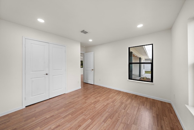 unfurnished bedroom featuring light hardwood / wood-style flooring and a closet