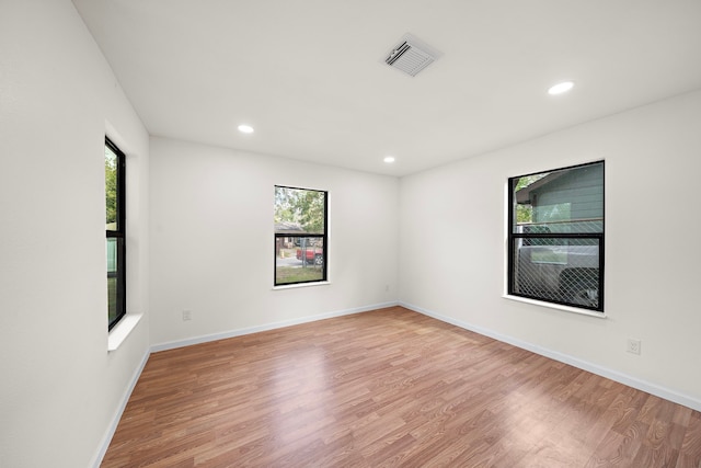 spare room featuring a wealth of natural light and light hardwood / wood-style flooring