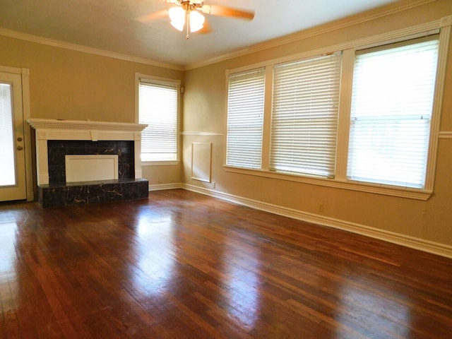 unfurnished living room with ornamental molding, a high end fireplace, dark hardwood / wood-style floors, and ceiling fan