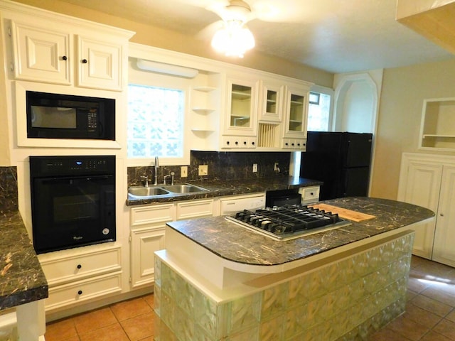 kitchen with black appliances, white cabinetry, light tile patterned floors, and tasteful backsplash