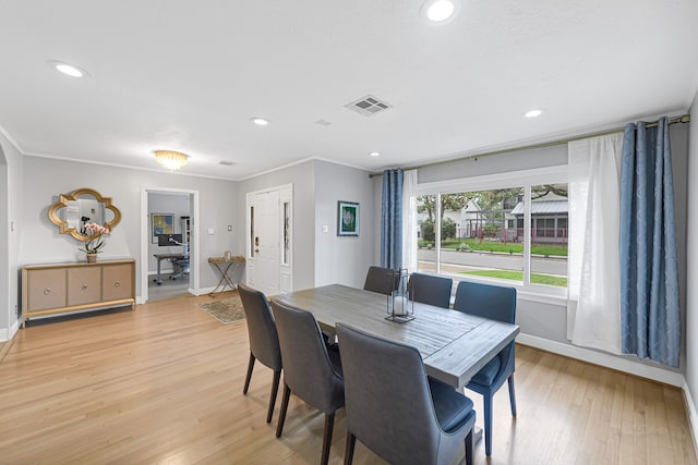 dining area featuring light hardwood / wood-style floors and crown molding