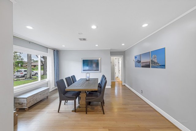 dining room featuring crown molding and light hardwood / wood-style flooring