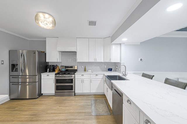 kitchen featuring a kitchen breakfast bar, light hardwood / wood-style flooring, custom range hood, sink, and appliances with stainless steel finishes