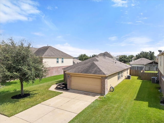 view of front facade with a garage, a front lawn, and central AC unit