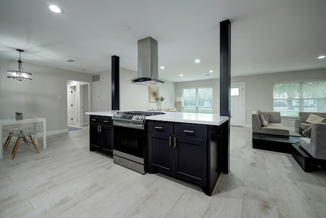 kitchen featuring a kitchen island, island exhaust hood, stainless steel range oven, pendant lighting, and light hardwood / wood-style flooring