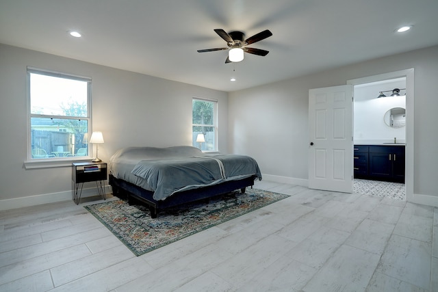 bedroom featuring ensuite bath, light wood-type flooring, and ceiling fan