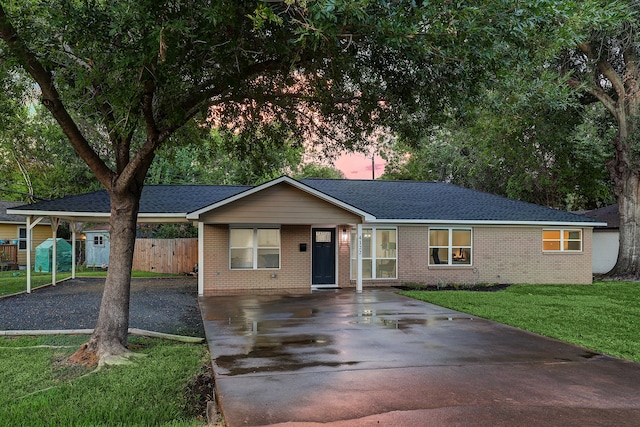 ranch-style home with a yard and a carport