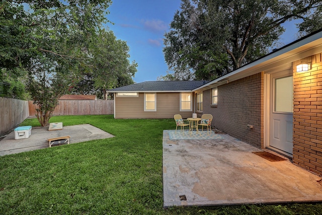 yard at dusk featuring a patio and a fire pit