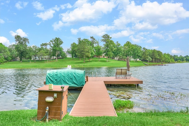 view of dock with a water view and a lawn