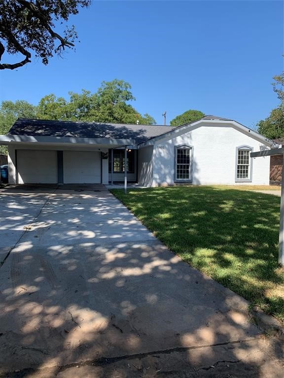 ranch-style house featuring a front lawn and a garage