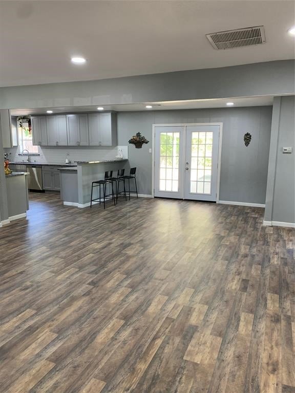 unfurnished living room with french doors, sink, and dark hardwood / wood-style flooring