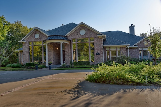 851 Elm Dr, Brenham, TX 77833 - view of front of property featuring a chimney, brick siding, and a shingled roof