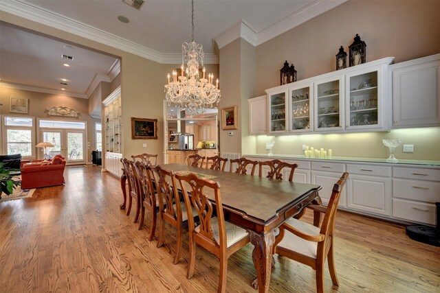 851 Elm Dr, Brenham, TX 77833 - dining space featuring a chandelier, light wood-style flooring, and crown molding