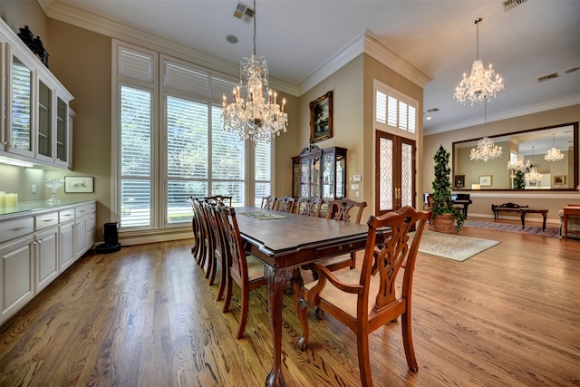 dining room featuring an inviting chandelier, ornamental molding, and light wood-type flooring