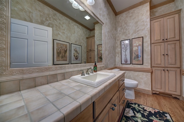 bathroom featuring vanity, ornamental molding, wood-type flooring, and toilet