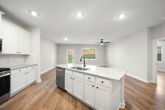 kitchen with sink, light wood-type flooring, an island with sink, stainless steel appliances, and white cabinets