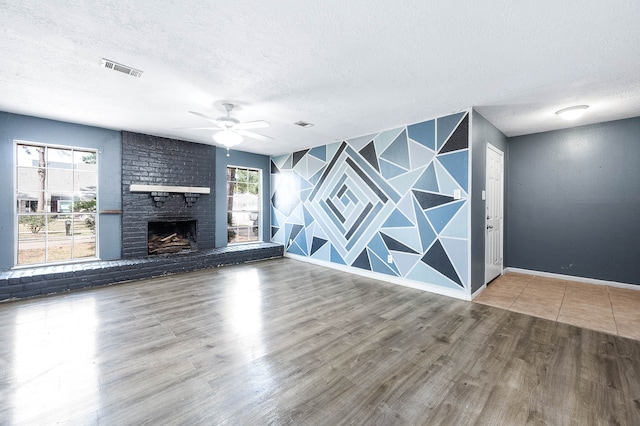 unfurnished living room featuring hardwood / wood-style flooring, a textured ceiling, and a wealth of natural light