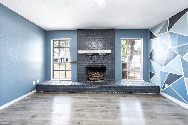 unfurnished living room with hardwood / wood-style floors, a fireplace, and ceiling fan