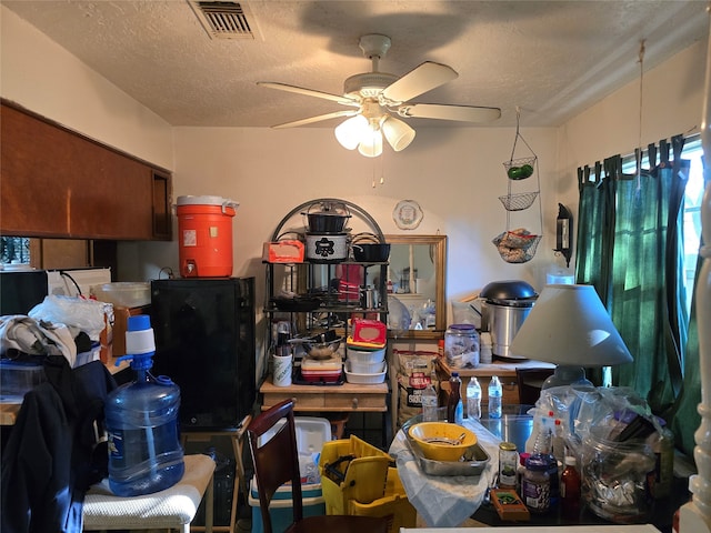 interior space with ceiling fan and a textured ceiling