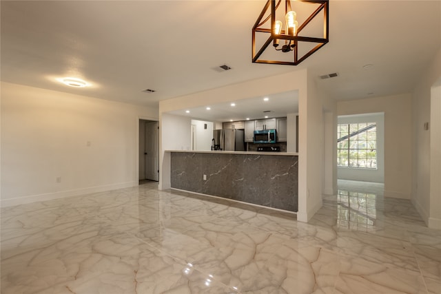 unfurnished living room with a chandelier