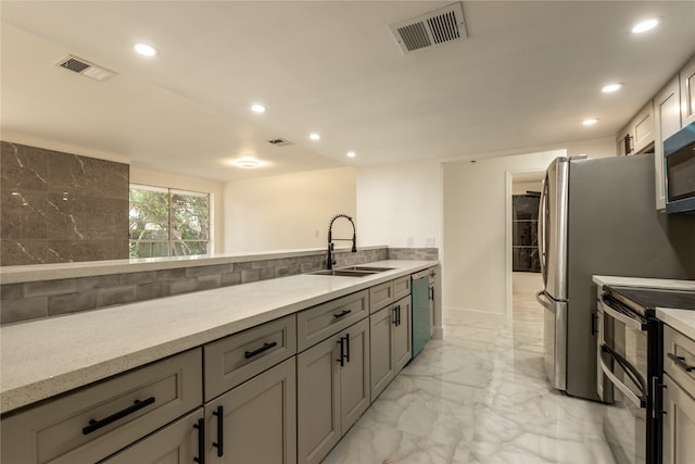 kitchen featuring gray cabinetry, backsplash, appliances with stainless steel finishes, and sink