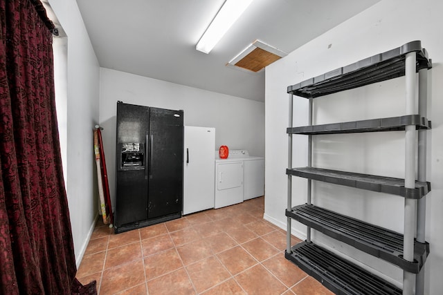 interior space with light tile patterned floors and washing machine and clothes dryer