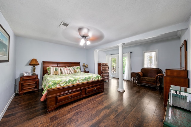 bedroom featuring dark hardwood / wood-style flooring, ornate columns, a textured ceiling, and ceiling fan